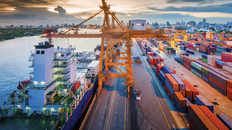 Cargo ship in the harbor at sunset.